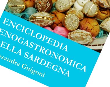 Book cover: Enciclopedia Enogastronomica della Sardegna on a bright blue banner over a background of decorated pastries/cookies, rotated diagonal view.