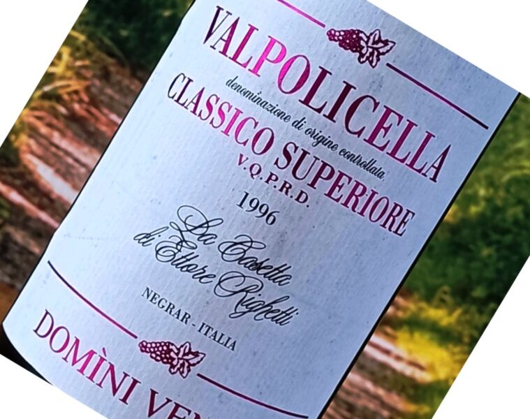 Close-up of a wine bottle label reading 'Valpolicella Classico Superiore' with the year 1996 visible, set outdoors.
