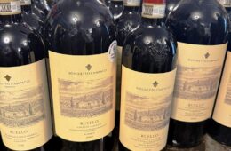 Bottles of Boschetto Campacci Ruello Chianti Classico Riserva wine lined up on a shelf with beige labels.