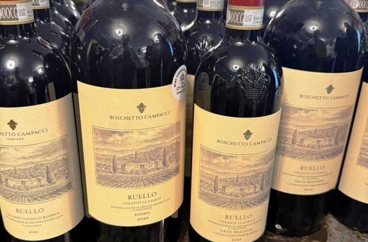 Bottles of Boschetto Campacci Ruello Chianti Classico Riserva wine lined up on a shelf with beige labels.