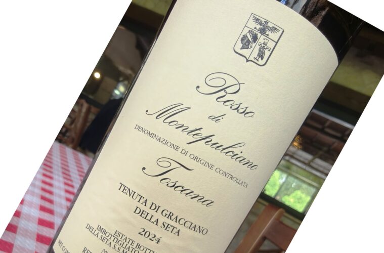 Close-up of a wine bottle label with a crest at the top and elegant cursive text, likely a Montepulciano red wine.