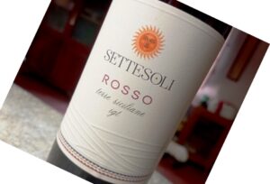 Wine bottle labeled Sette Soli Rosso with a sun emblem, Terre Siciliane IGT, tilted on a countertop