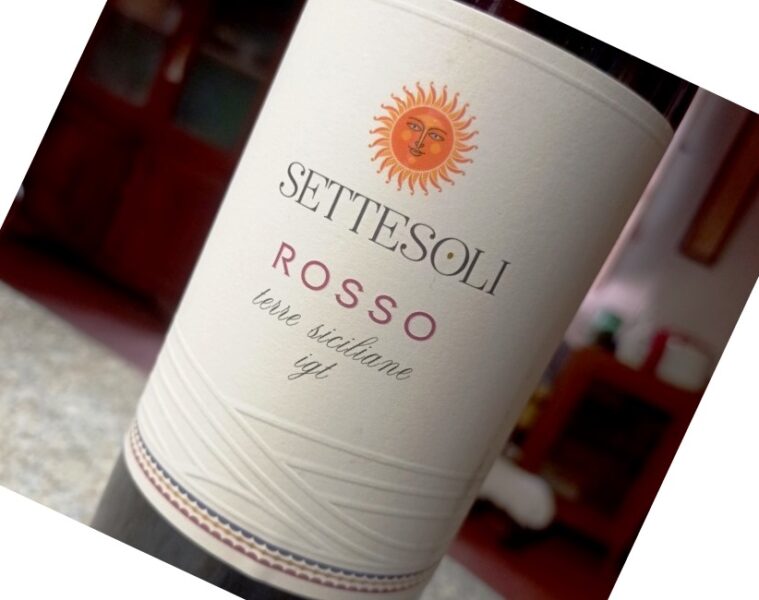 Wine bottle labeled Sette Soli Rosso with a sun emblem, Terre Siciliane IGT, tilted on a countertop