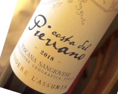 Close-up of a tilted wine bottle label with handwritten script and the year 2018 visible.