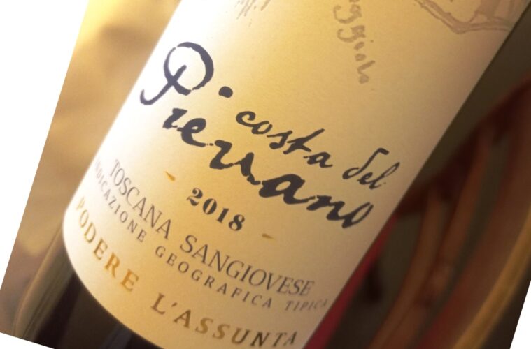 Close-up of a tilted wine bottle label with handwritten script and the year 2018 visible.