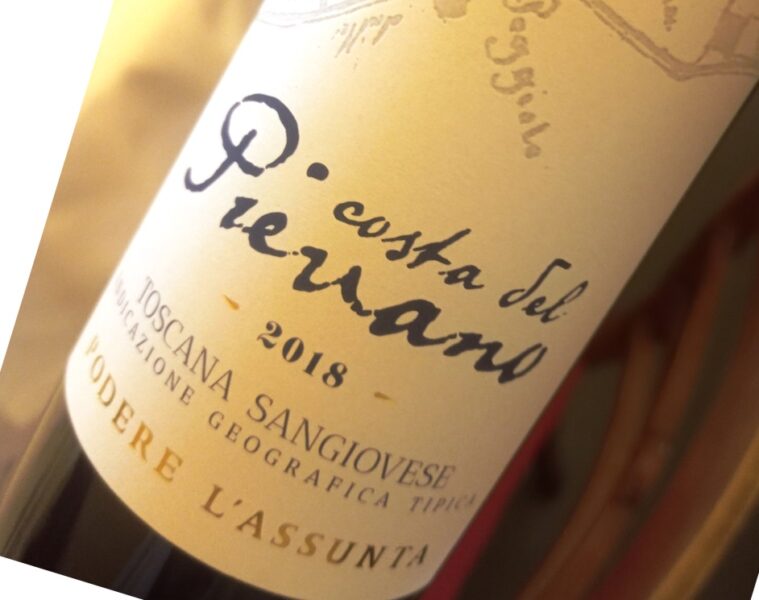 Close-up of a tilted wine bottle label with handwritten script and the year 2018 visible.