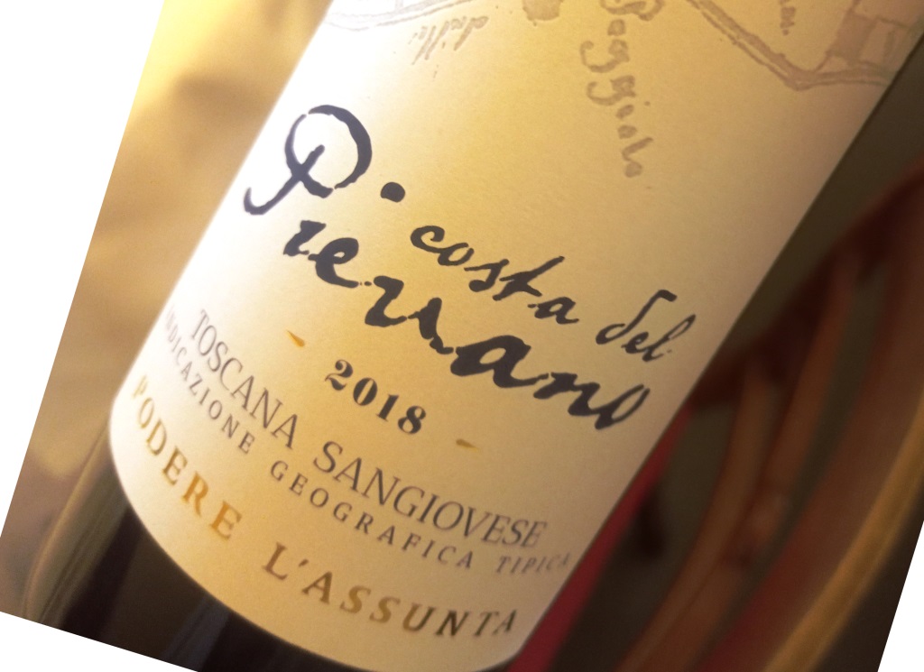 Close-up of a tilted wine bottle label with handwritten script and the year 2018 visible.
