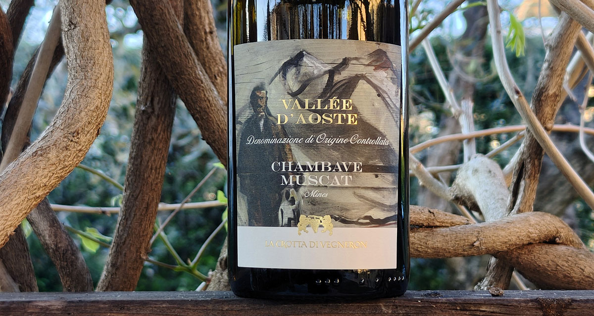 Wine bottle with label 'Vallée d'Aoste Chambave Muscat', featuring a mountain scene and gold accents among tree branches