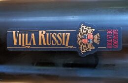 Dark wine bottle with a blue label reading 'SAUVIGNON DE LA TOUR' and a gold crest; vertical gold lettering along the label.