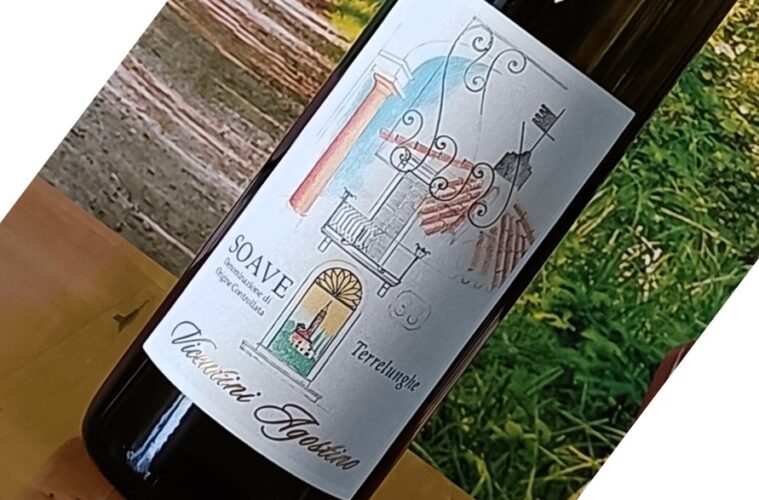 Bottle of wine on a wooden table with a decorative label featuring architectural motifs and the word 'Soave' (tilted in the photo).