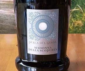 Wine bottle with a silver ornate label featuring a circular emblem and the text 'MADONNA DELLA SCOPERTA'.